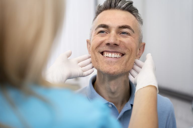 close up doctor checking man | Montagna Studi Dentistici | Dentista a Bovolone